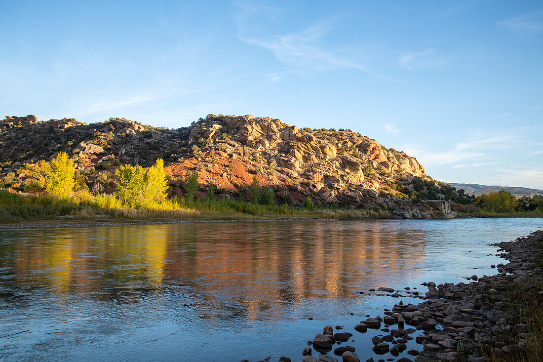 Abendlicht beleuchtet Berge und Büsche entlang des Green Rivers im Dinosaur National Monument; Utah, Vereinigte Staaten von Amerika