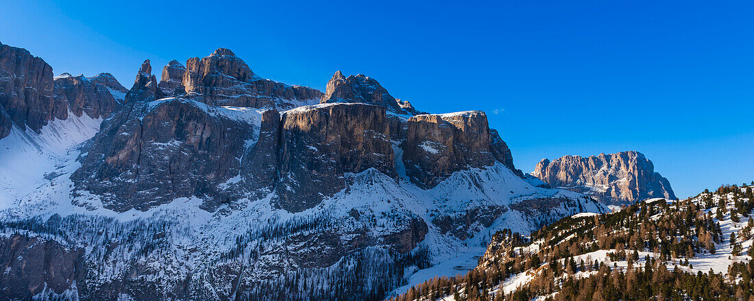 Rocky peaks of the Sella Group covered in snow with Val Di Mezdi on the left and Saslong on back right, at Colfosco Corvara in Alta Badia Mountain Region; Dolomites, Italy