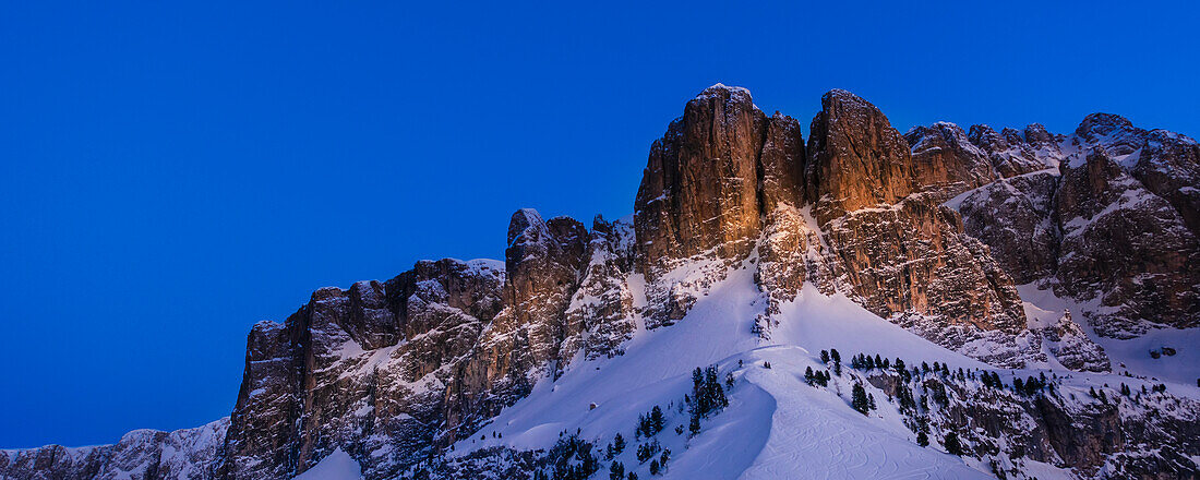 Zerklüftete, schneebedeckte Gipfel der Sellagruppe am Grödnerjoch im Grödnertal, Bezirk Bozen, in der Dämmerung; Trentino-Südtirol, Dolomiten, Italien