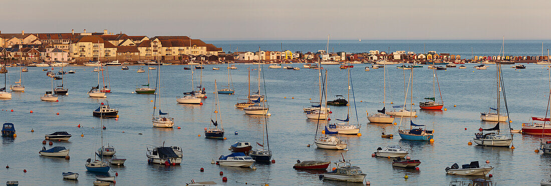 Blick auf Boote, die in der Dämmerung entlang des Küstenortes Teignmouth an der Mündung des Flusses Teign im Hafen vertäut sind; Teignmouth, Devon, England, Großbritannien