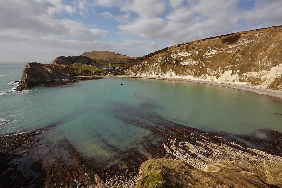 Turquoise waters at Lulworth Cove with the chalk cliffs overlooking the Atlantic Ocean on the Jurassic Coast World Heritage Site; Dorset, England, Great Britain