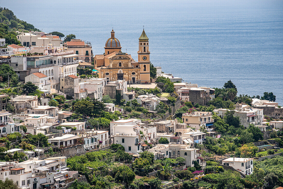 Overview of Praiano with the tiled dome of Parrocchia Di San Gennaro dominating the skyline of the seaside resort town on the Amalfi Coast; Praiano, Salerno, Italy