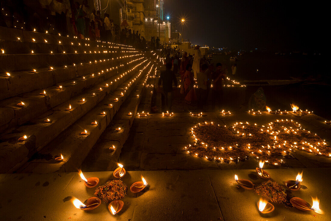 People gather at the ghats in Varanasi for Dev Deepawali with candles lit at night in celebration of the the festival of Kartik Poornima; Varanasi, India
