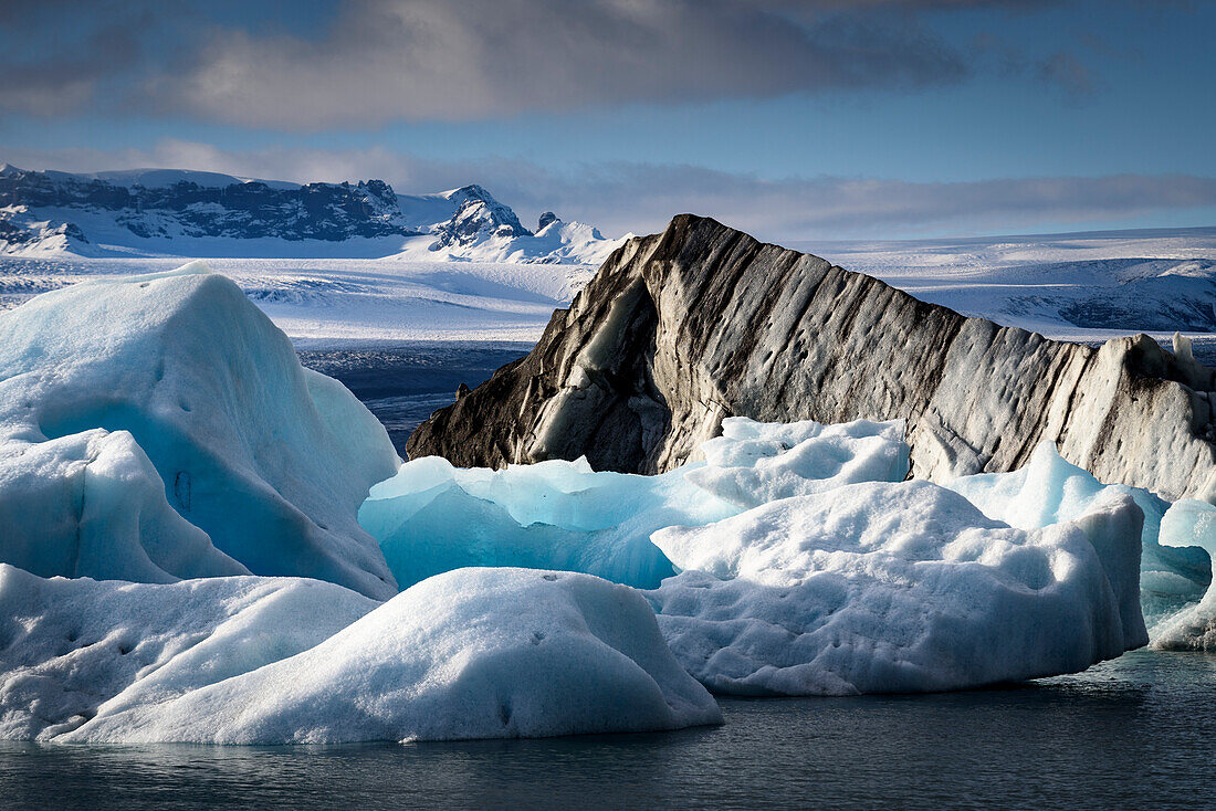 Dramatischer Blick auf schneebedeckte Landschaft und Eisberge entlang der Küste der Jokulsarlon Gletscherlagune; Vatnajokull National Park, Island