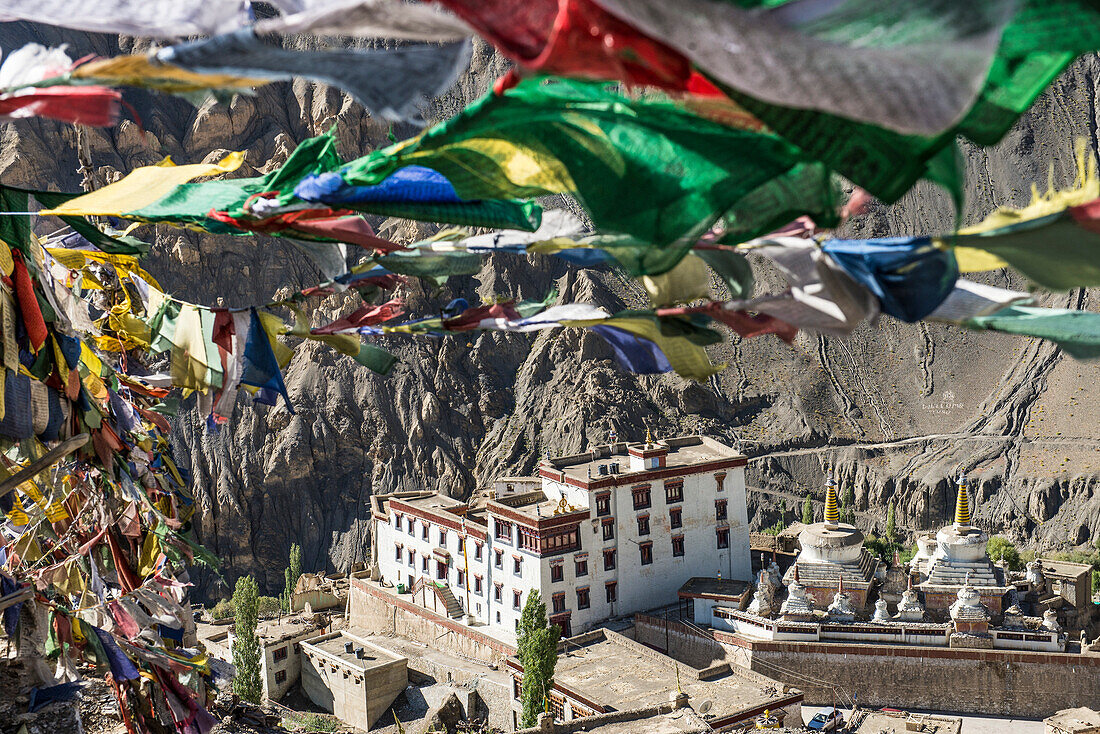Überblick über das tibetisch-buddhistische Lamayuru-Kloster auf einer Klippe in Lamayouro im Leh-Distrikt in der Ladakh-Region, darüber wehen bunte Gebetsfahnen; Jammu und Kaschmir, Indien