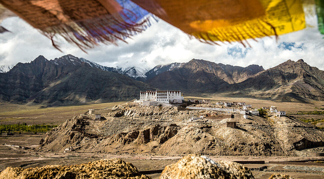 Überblick über die tibetisch-buddhistische Stakna Gompa auf einem Felsvorsprung in den Ausläufern des Himalaya, Bezirk Leh, mit bunten Gebetsfahnen darüber; Jammu und Kaschmir, Indien