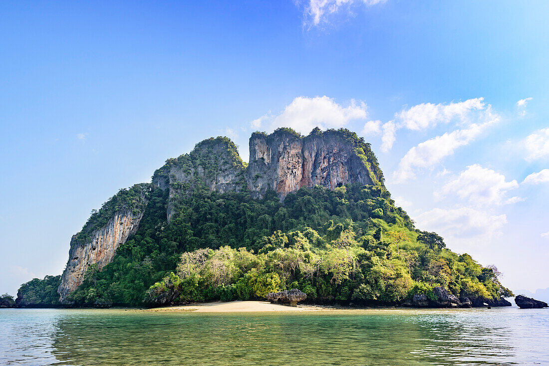 Blick auf einen kleinen Strand entlang der Küste einer tropischen Insel mit Klippen aus Karstfelsen und üppiger Vegetation; Phang Nga Bay, Thailand