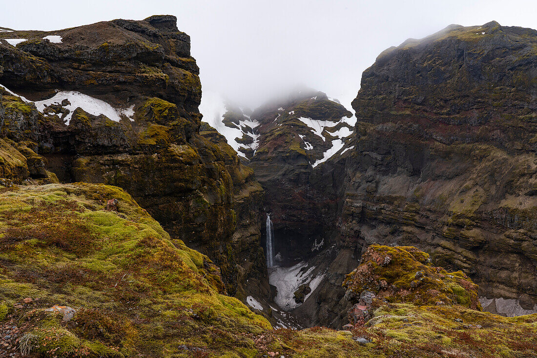 Ein Paradies für Wanderer, Mulagljufur Canyon mit Blick auf einen abgelegenen Wasserfall vor den felsigen Klippen; Vik, Südisland, Island