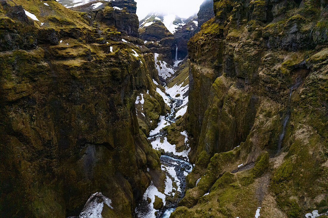 Ein Paradies für Wanderer, der Mulagljufur Canyon mit erstaunlichem Blick auf einen gewundenen Gebirgsfluss und einen abgelegenen Wasserfall vor den felsigen Klippen; Vik, Südisland, Island
