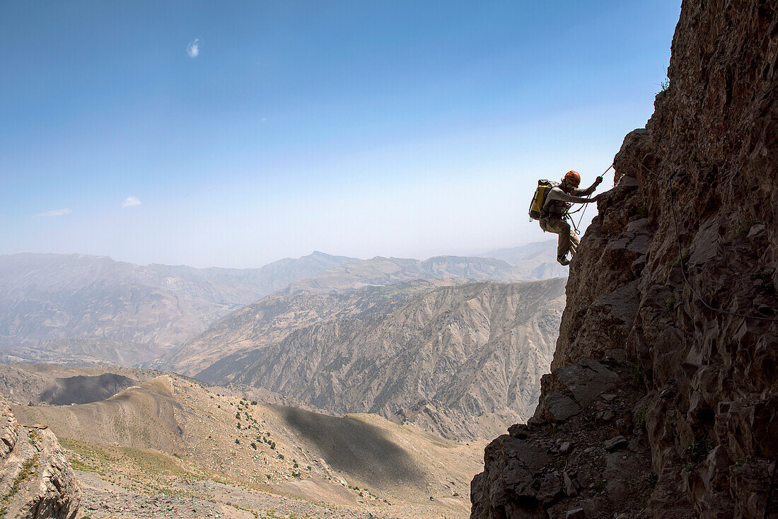 A National Geographic writer climbs toward Dark Star, a limestone cave system in Uzbekistan's Boysuntov Range.