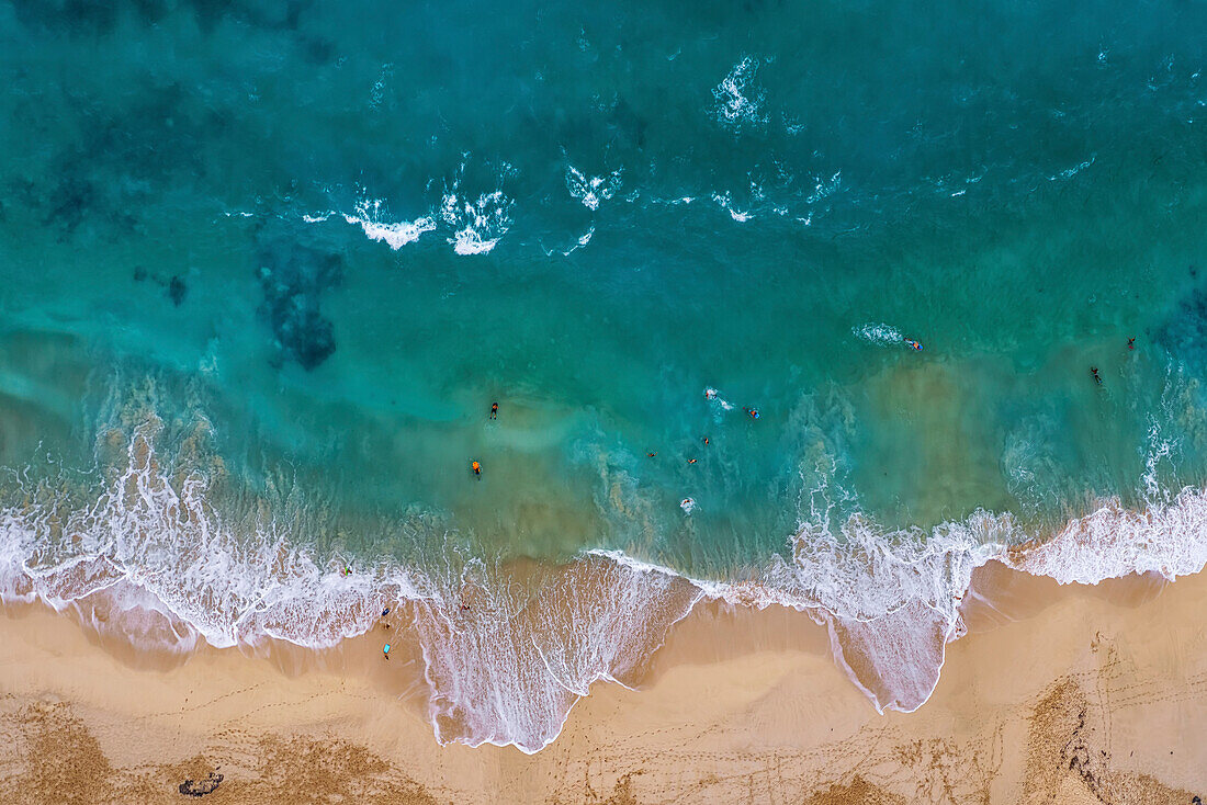 Overhead view of beachgoers at seaside with sand and turquoise waters of Makapuu Beach; Makapuu, Oahu, Hawaii, United States of America
