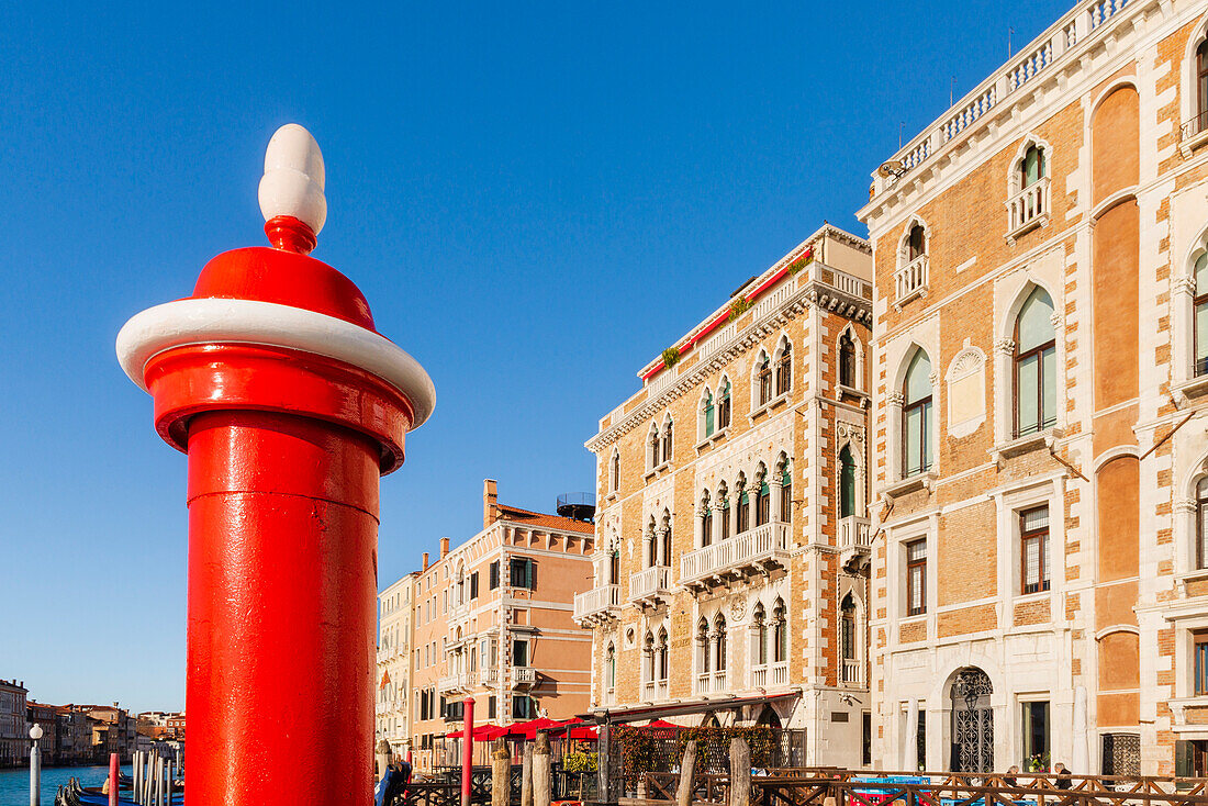 Close-up of a canal pole and historic buildings along the Grand Canal in the background; Veneto, Venice, Italy