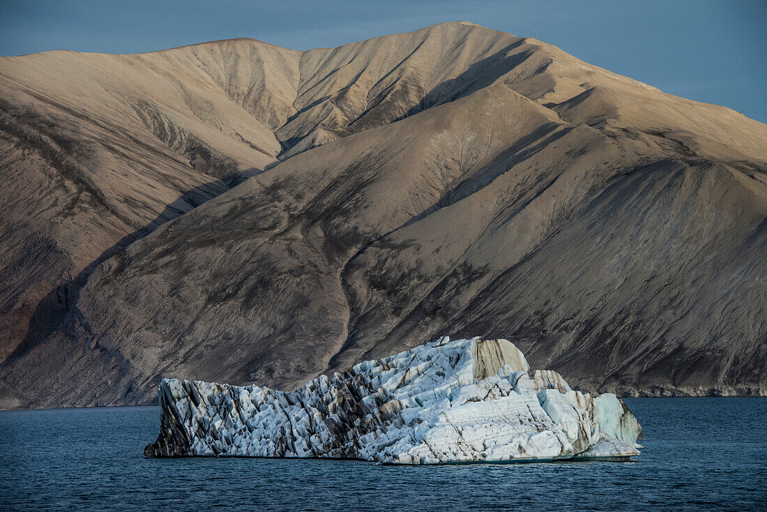 Silt streaked iceberg floating in Greenland's Kaiser Franz Joseph Fjord; East Greenland, Greenland