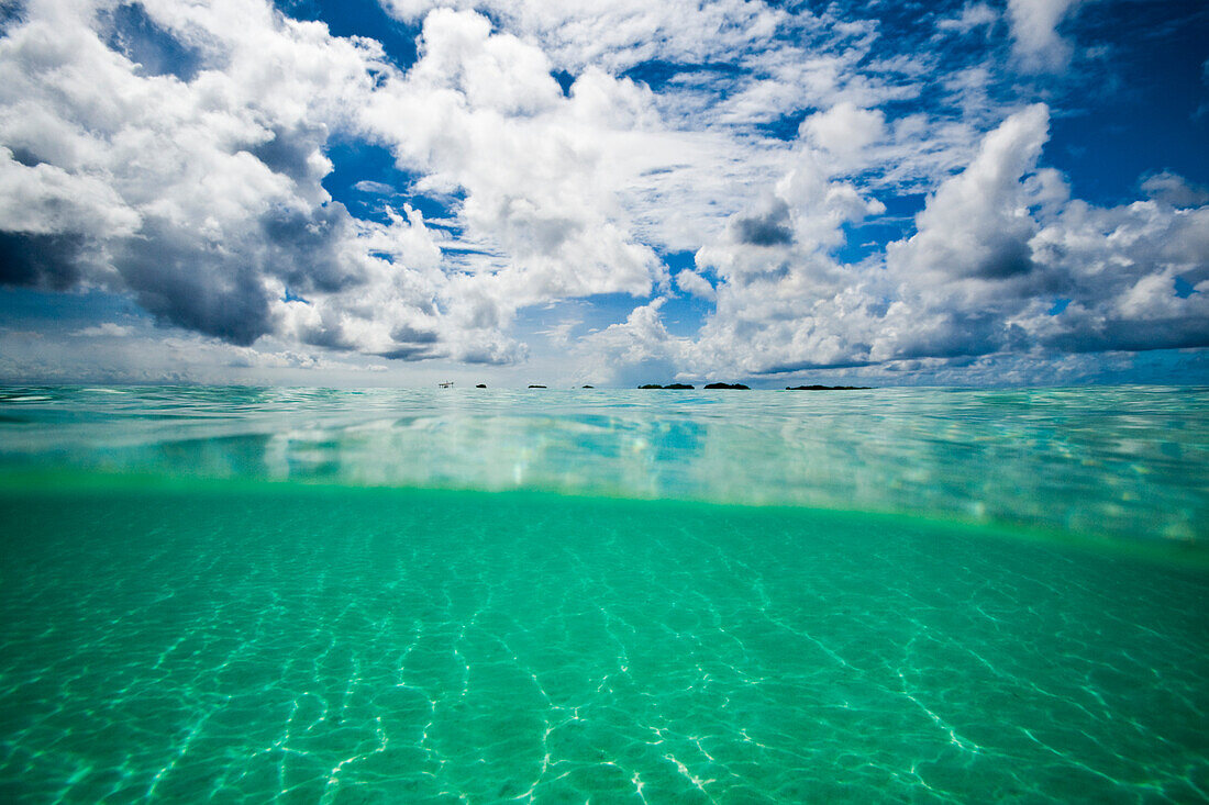 Gesplittete Ansicht von Unterwasser, Oberflächenebene des Karibischen Meeres und bewölktem Himmel vor der Insel Aruba; Aruba, Königreich der Niederlande