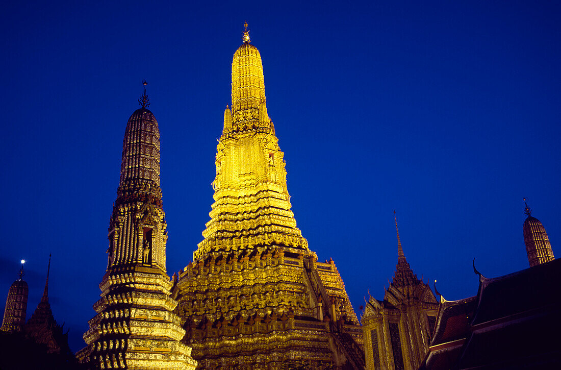 Moon in the clear sky above Wat Arun or Temple of the Dawn; Bangkok, Thailand