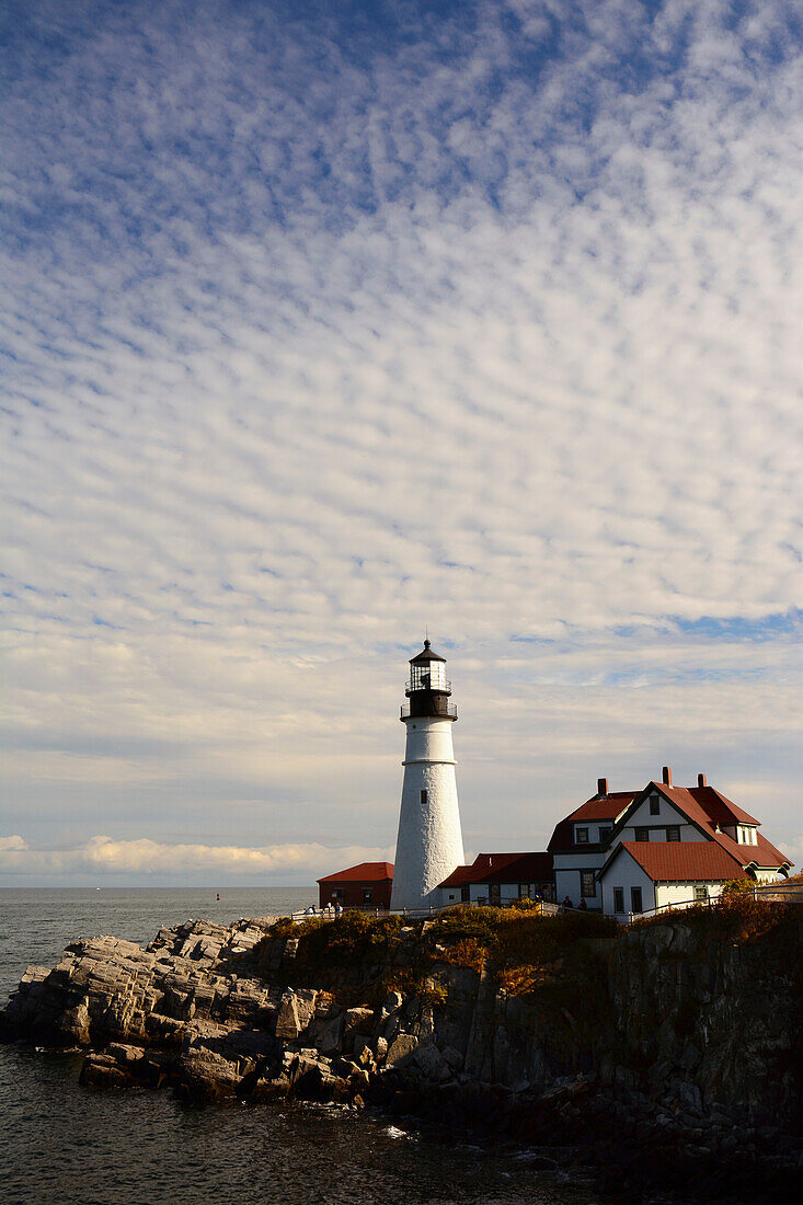 Scenic view of the Portland Head Lighthouse and the rocky coast.; Cape Elizabeth, Gulf of Maine, Portland Head Light, Maine.