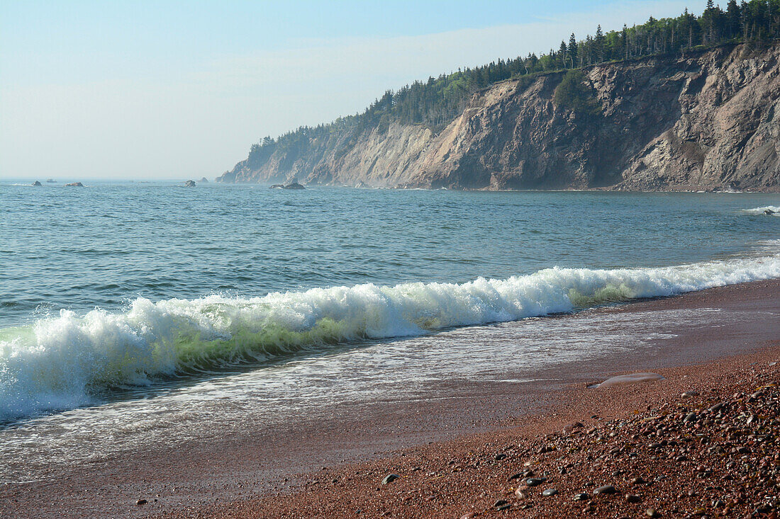 A wave meets the shore at Broad Cove, in Cape Breton Highlands National Park.; Ingonish, Broad Cove, Cape Breton Highlands National Park, Cape Breton, Nova Scotia, Canada.