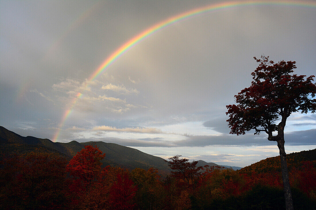A double rainbow appears over the White Mountains on a fall morning.; Hancock, New Hampshire, USA.