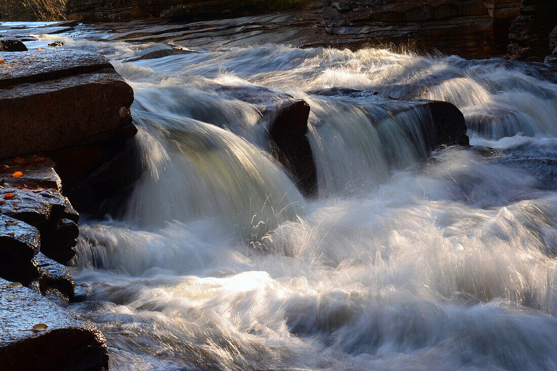Water cascading over rock at the Lower Ammonoosuc Falls in October.; New Hampshire, USA.