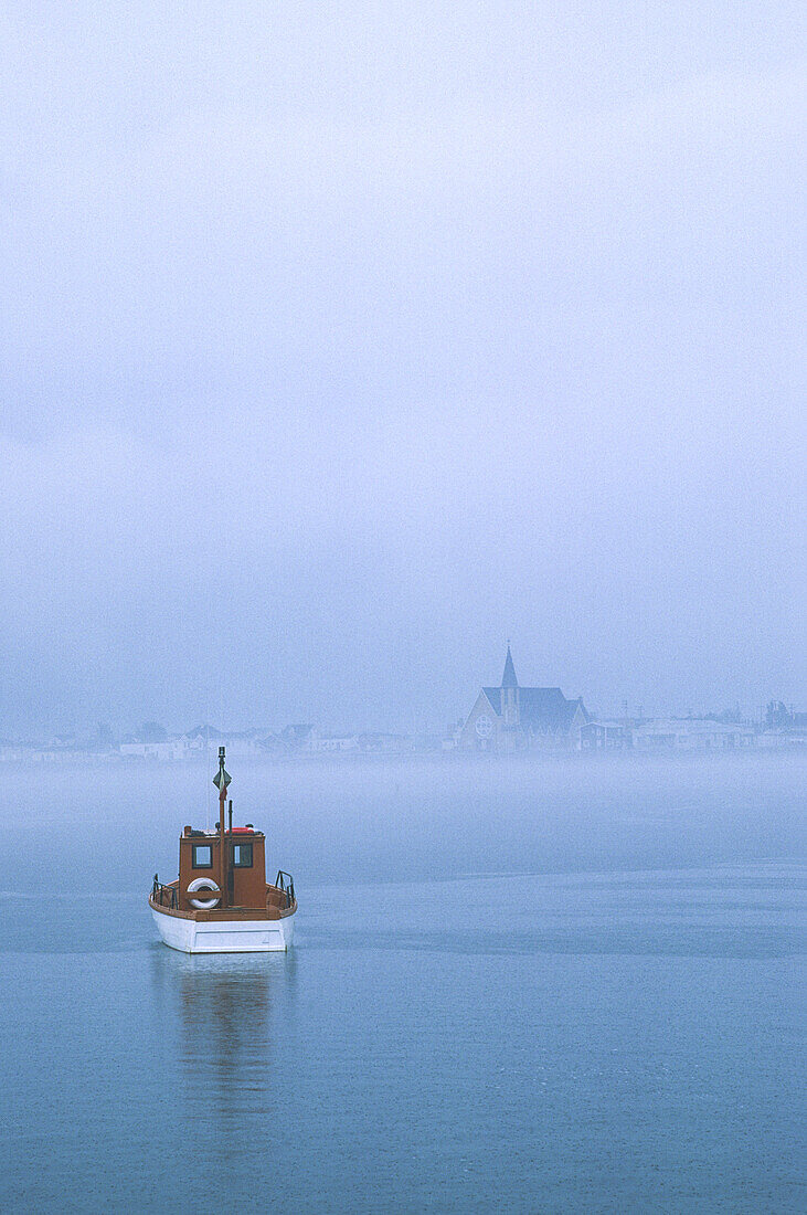 Fischerboot und die Stadt Mont Lois im Nebel; Mont Lois, Gaspe Halbinsel, Quebec, Kanada