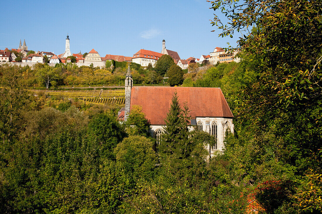 Eine Kirche, umgeben von Bäumen und anderen Gebäuden im Hintergrund; Rothenburg Ob Der Tauber Bayern Deutschland