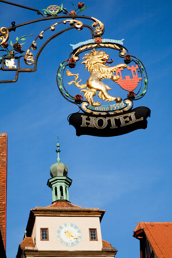 Hanging Sign For A Hotel And A Clock Tower On A Building; Rothenburg Ob Der Tauber Bavaria Germany