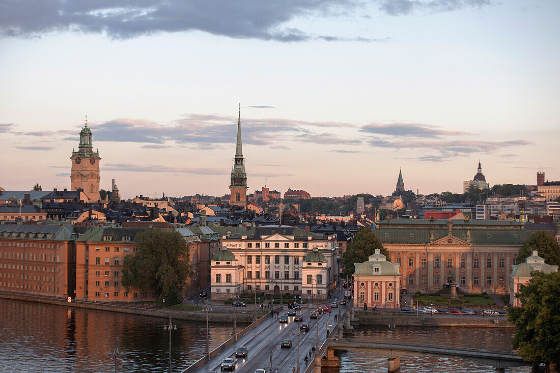 Stadtbild bei Sonnenuntergang mit einer Straße, die über Wasser führt; Stockholm Schweden