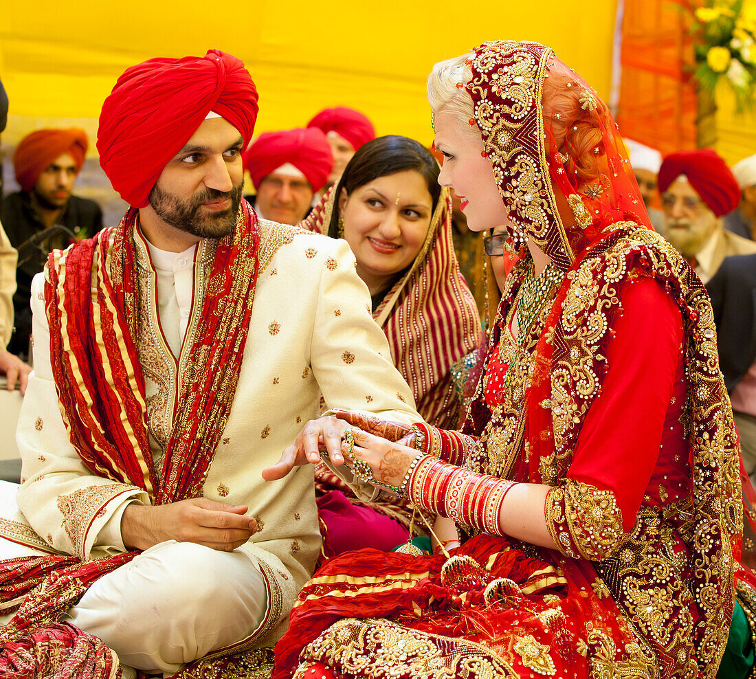 Braut und Bräutigam tauschen bei einer indischen Hochzeitszeremonie die Ringe aus; Ludhiana, Punjab, Indien