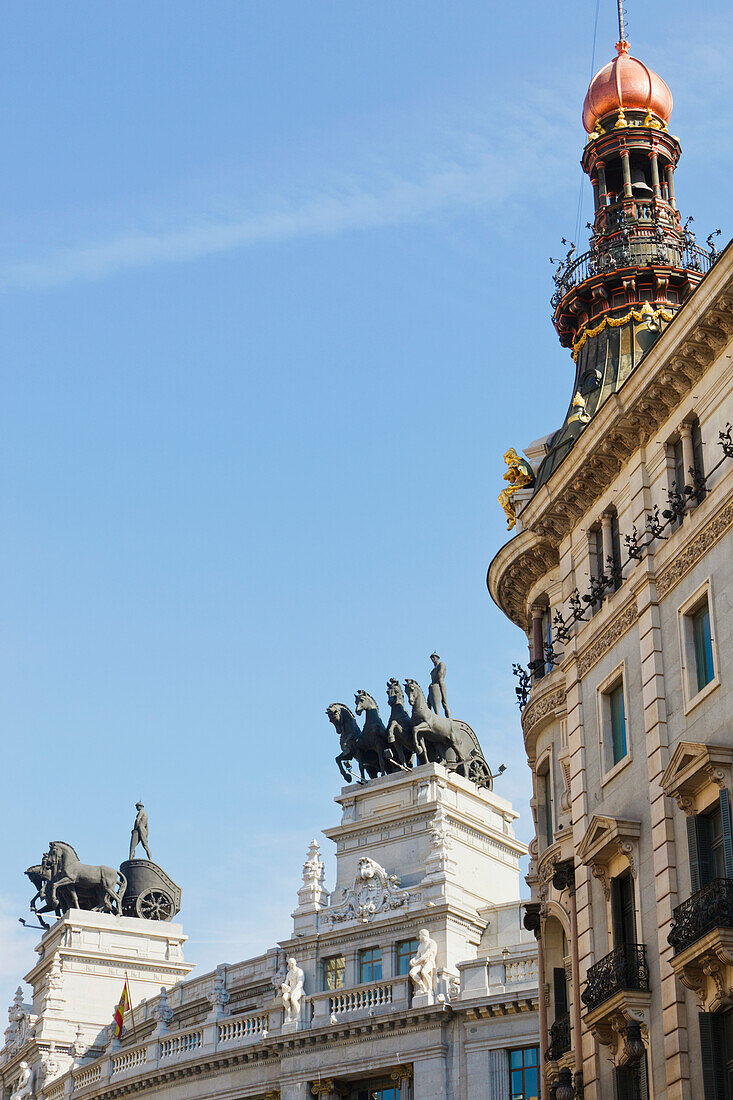 Quadrigas auf dem Dach des Banco De Bilbao-Gebäudes (Statue von vier Pferden, die einen zweirädrigen Wagen ziehen); rechts das Gebäude des Palacio De La Equitativa; Madrid Spanien