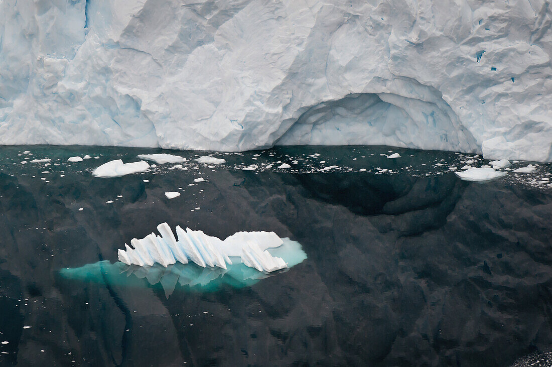 Glacier Reflected In The Water Along The Coastline; Antarctica