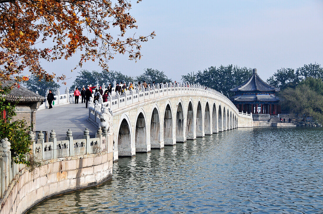 Pedestrians Crossing The Bridge Over A River; Beijing China