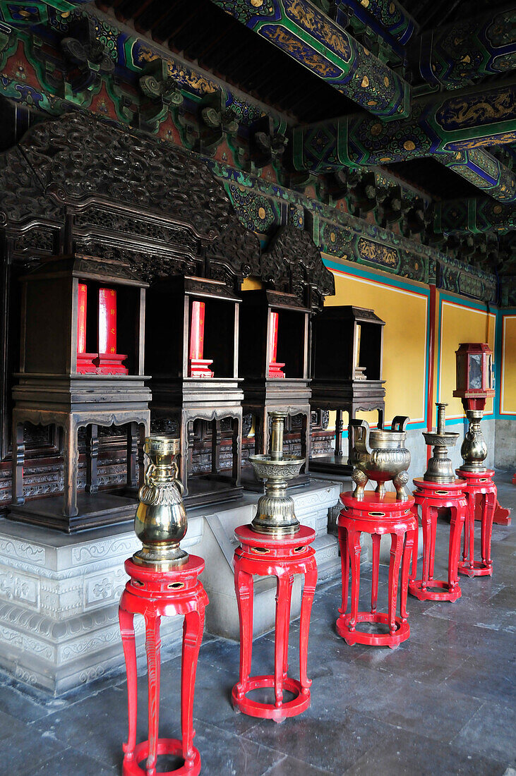 Goldene Urnen stehen in einer Reihe auf roten Tischen; Peking China