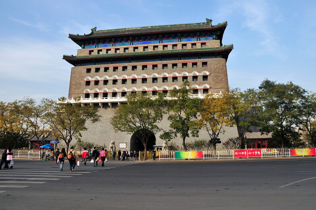 Fußgänger, die eine Straße in Richtung eines Gebäudes überqueren; Peking China