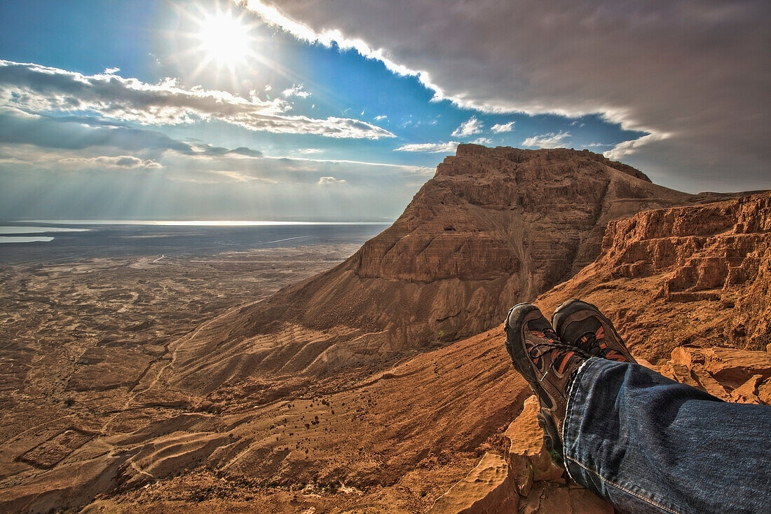 Ein Mann sitzt und schaut über das Tote Meer bei Masada; Israel