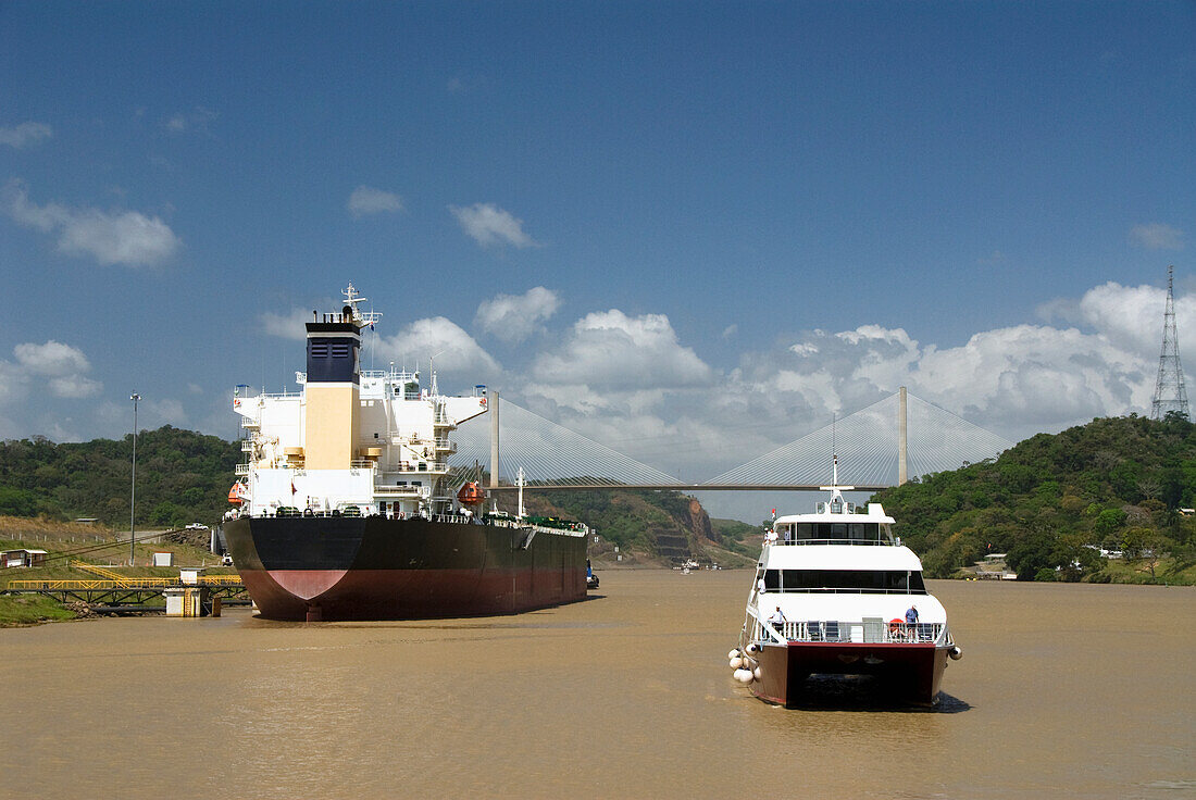 Panama, Panama Canal, cruise boat coming into Pedro Miguel Lock, new Millennium Bridge with waiting ship