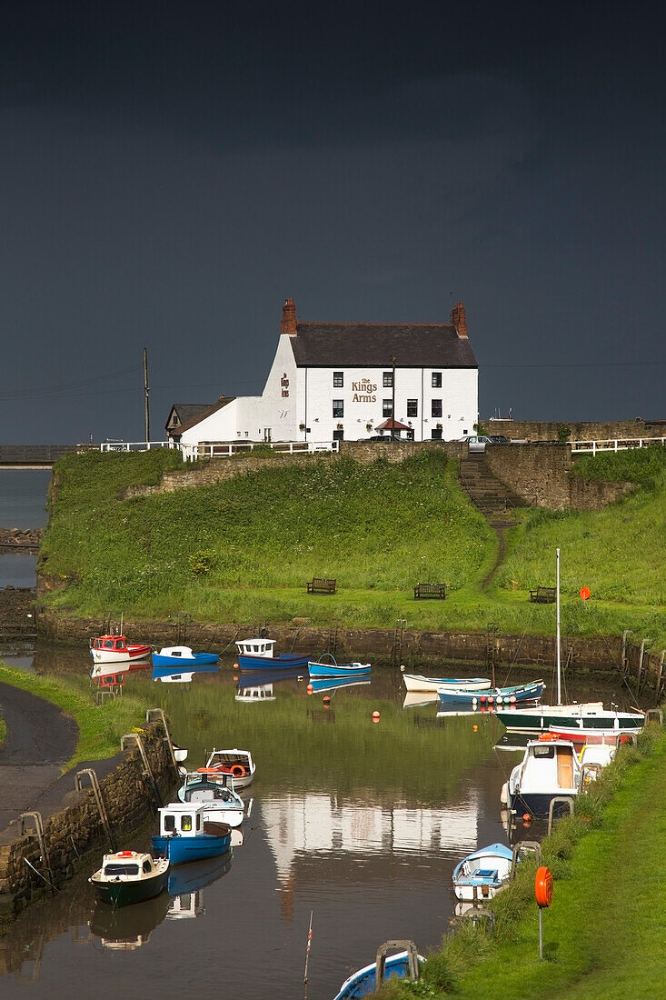 Dunkle Gewitterwolken über einem Dorf an der Küste; Seaton Sluice Northumberland England