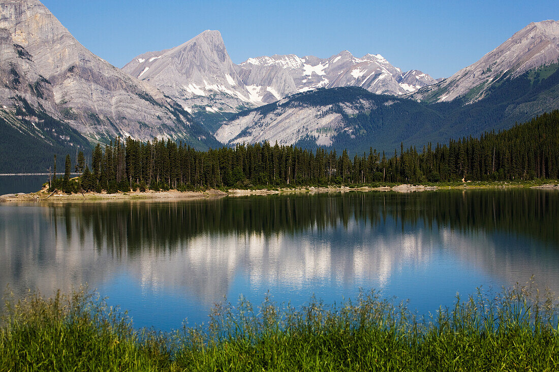 Mountain Lake Reflecting Mountain Range With Snow And Blue Sky; Kananaskis Provincial Park Alberta Canada