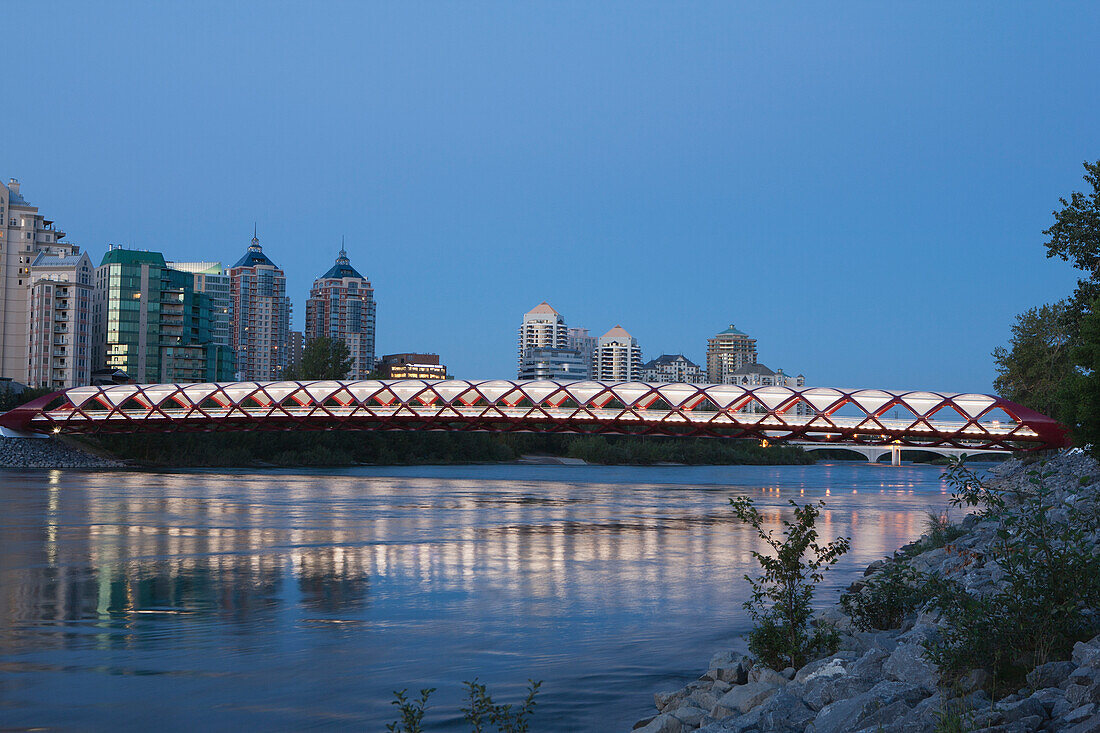 Rote Brücke über den Bow River bei Dämmerung mit Lichtern; Calgary Alberta Kanada
