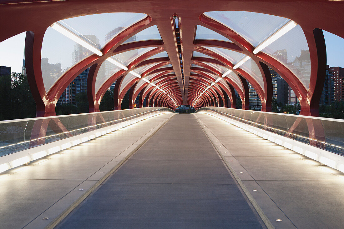 Rote Brücke über den Bow River in der Dämmerung mit Lichtern; Calgary Alberta Kanada