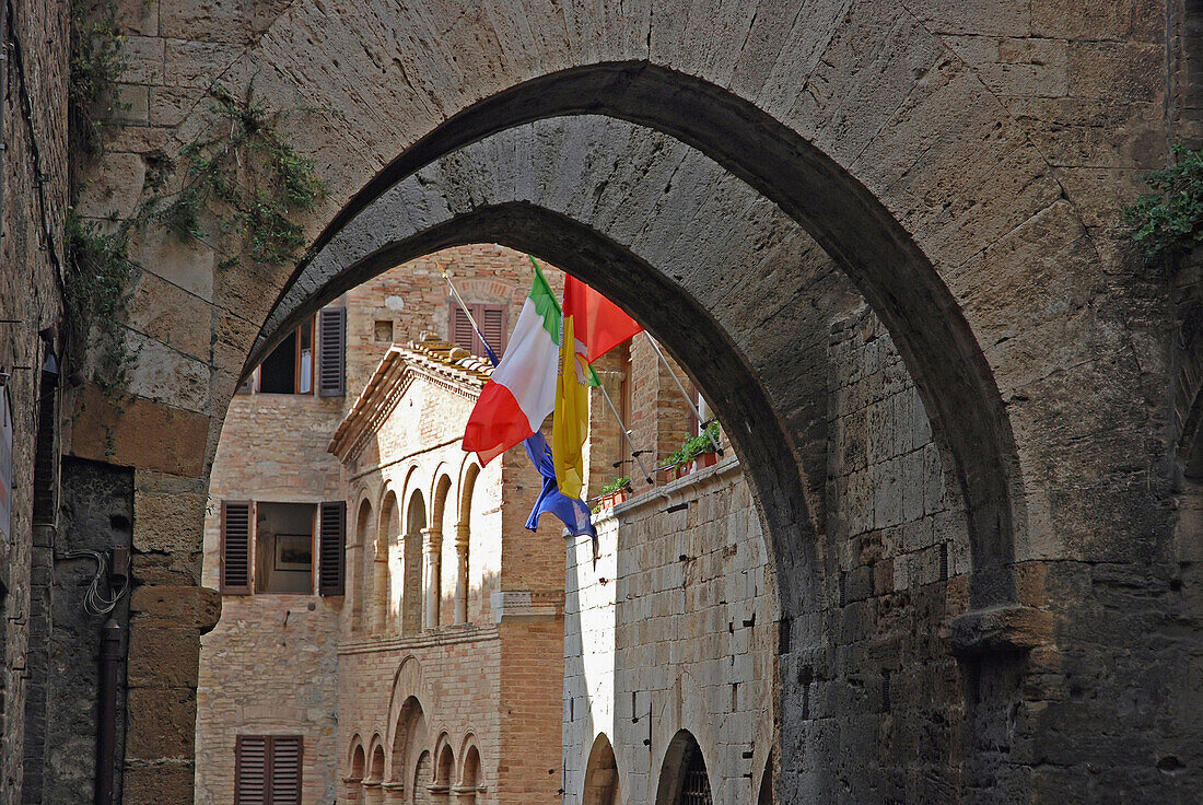 Arches In Stonework And Flags On The Edge Of A Building; San Gimignano Italy