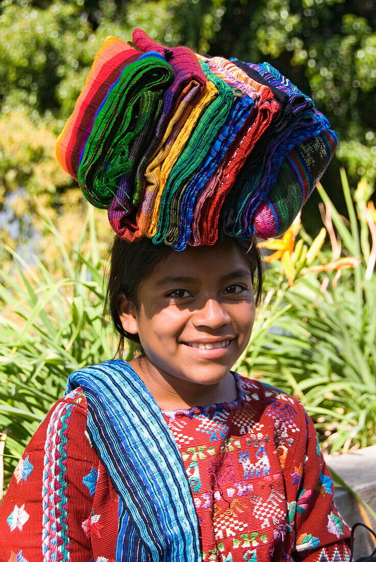 Guatemala, Atitlan-See, indigenes Mädchen, das Textilien zum Verkauf auf dem Kopf trägt