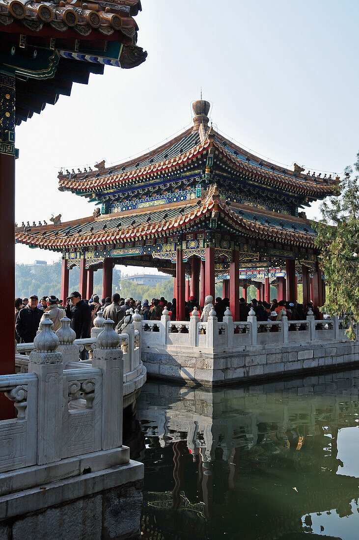 Eine Menschenmenge versammelt sich unter einem traditionellen chinesischen Gebäude; Peking China