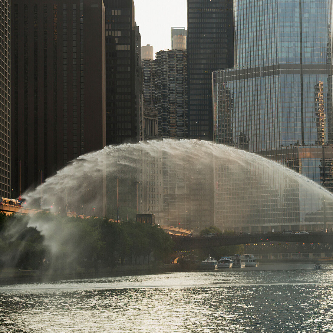Wasser sprüht über einen Fluss mit Gebäuden im Hintergrund; Chicago Illinois Vereinigte Staaten Von Amerika
