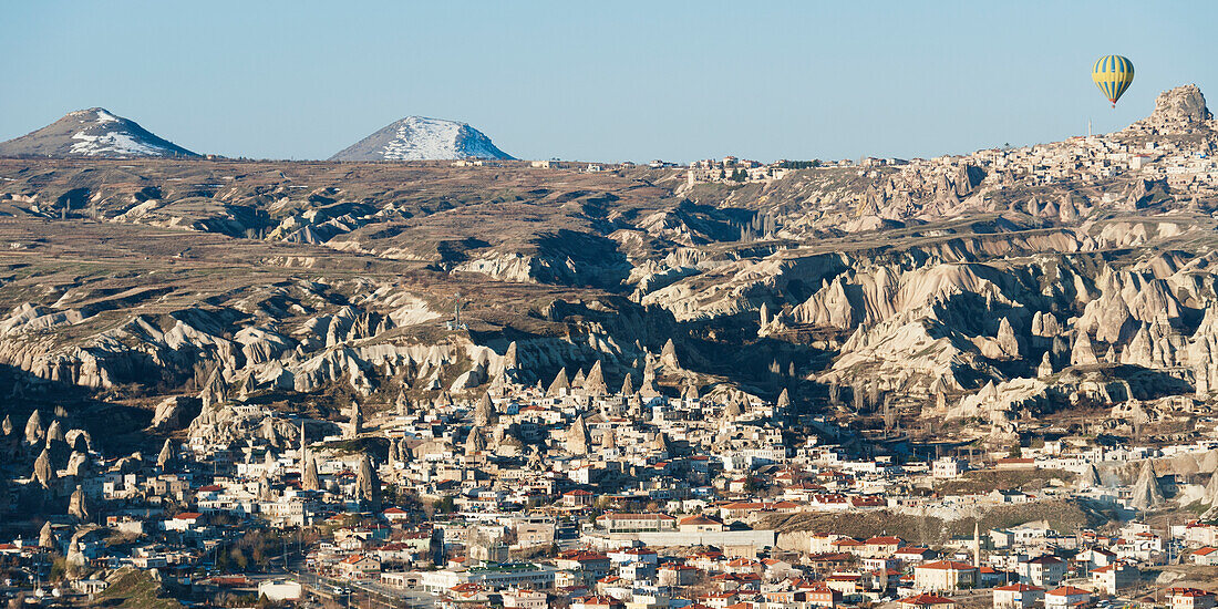 Hot Air Balloon In Flight Above The City; Goreme Nevsehir Turkey