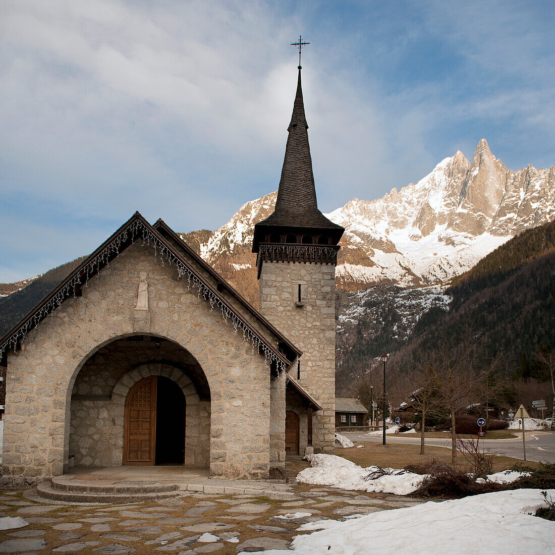 Eine Kirche mit einem Kirchturm und Bergen im Hintergrund; Chamonix-Mont-Blanc Rhone-Alpes Frankreich