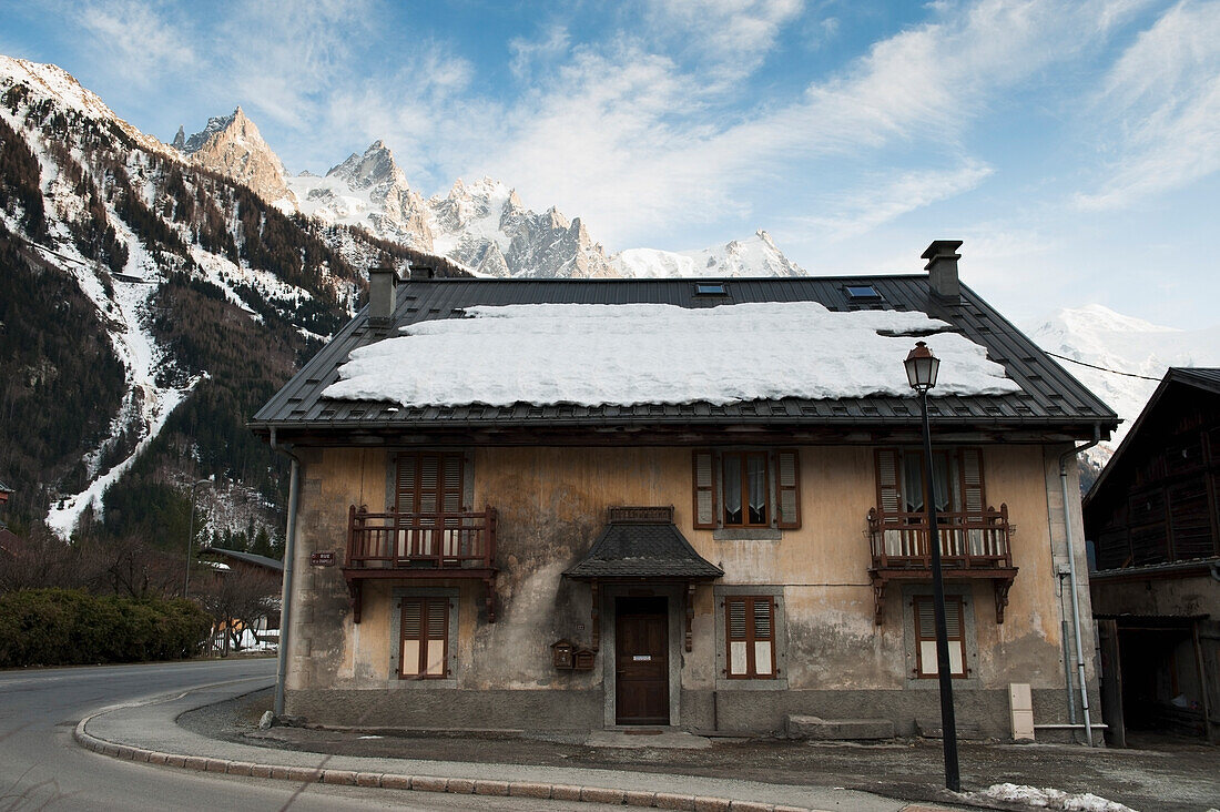 Schnee auf dem Dach eines Gebäudes mit den französischen Alpen im Hintergrund; Chamonix-Mont-Blanc Rhone-Alpes Frankreich