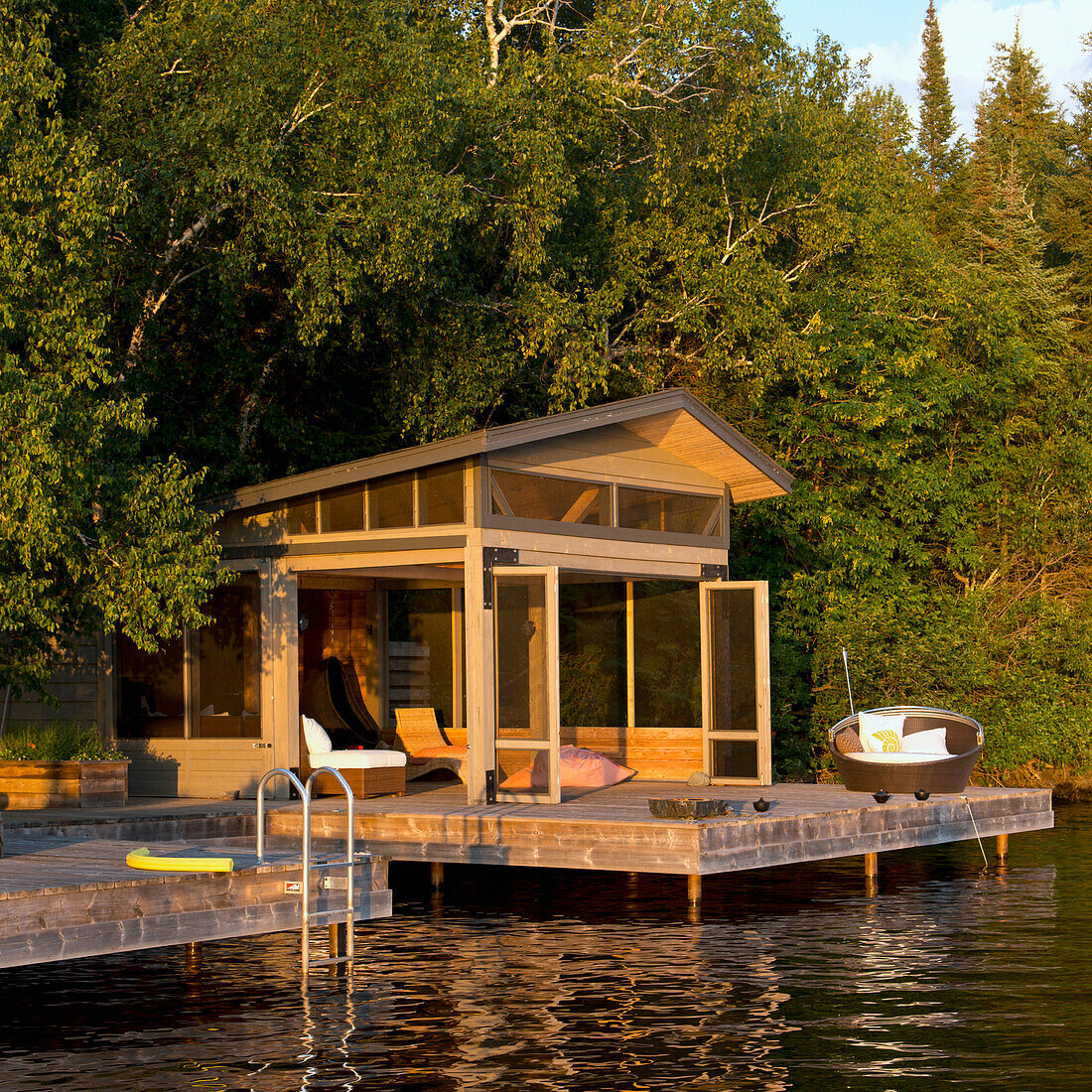 A Cottage With Wooden Dock On The Water's Edge; Lake Of The Woods Ontario Canada