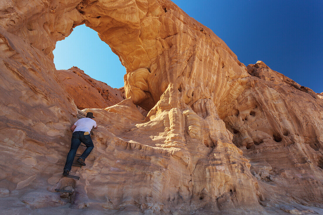 A Man Climbs A Sandstone Rock Formation; Timna Park Arabah Israel