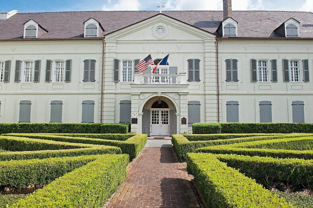 USA, New Orleans, Louisiana, White building with hedges lining paths and American flag