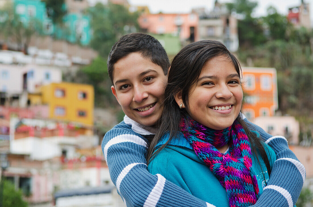 Portrait of siblings in front of suburbs houses; Guanajuato, Guanajuato, Mexico